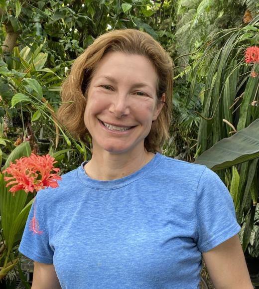 A woman surrounded by plants smiling