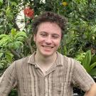 A student surrounded by plants smiling